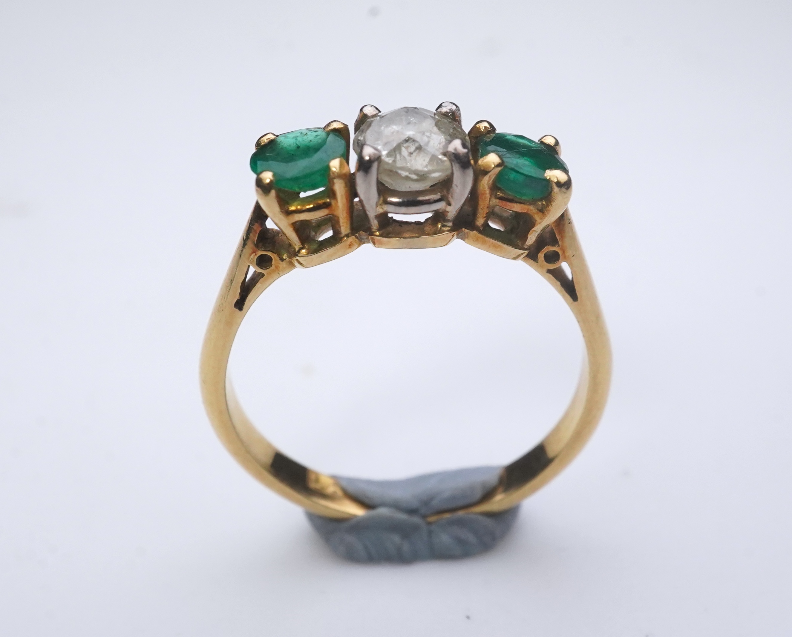 An emerald and diamond three-stone ring